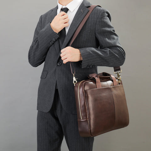 Man in a dark pinstripe suit holding The Modern Briefcase in rich brown.