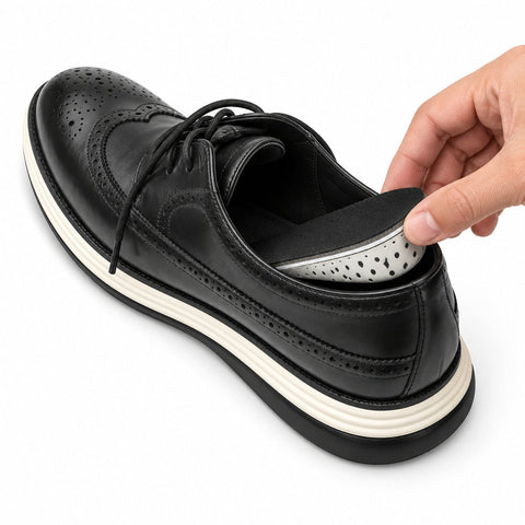 The Modern Insole being placed inside a black leather dress sneaker with a perforated design for a comfortable discreet height boost