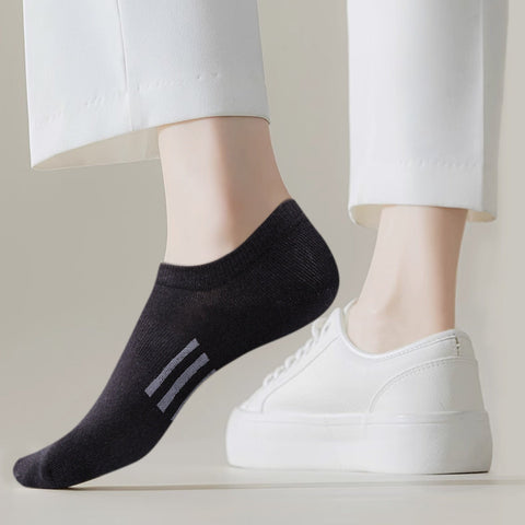 A black low-cut sock worn with a white casual sneaker.