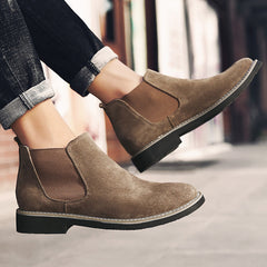 Brown suede shoes worn with rolled-up jeans on a blurred background