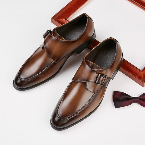 Pair of polished brown Lennox dress shoes with discreet height boost and buckle detail, styled alongside a burgundy bow tie and wooden frame on white background