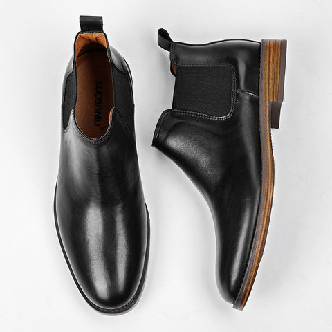 Wellington black leather men's dress shoes with a discreet height boost, featuring elastic side panels and stacked wooden heels for a sleek, comfortable elevator shoe design.