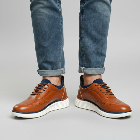 Pair of Prescott brown leather discreet height boost shoes with white cushioned soles worn with rolled-up blue jeans, showcasing modern elevator shoes for men.