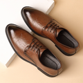 Brown leather dress shoes on a beige background