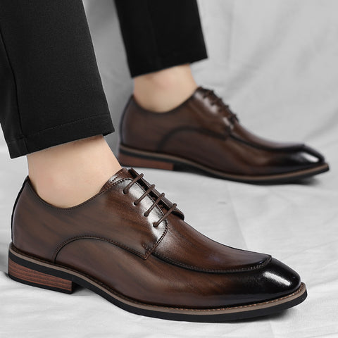 Brown dress shoes worn with black pants on a light gray background