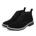 Black suede boots with white soles on a white background