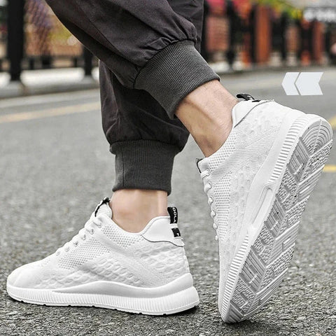 White sneakers worn on a street with a blurred background