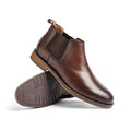 Pair of brown leather Wellington boots with elastic side panels and discreet height boost, featuring comfortable insoles and a sleek, modern design for men.