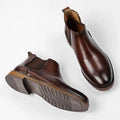 Pair of Wellington men's boots in polished brown leather with discreet height boost, featuring comfortable insoles and hidden lift design for a modern, elevated look.