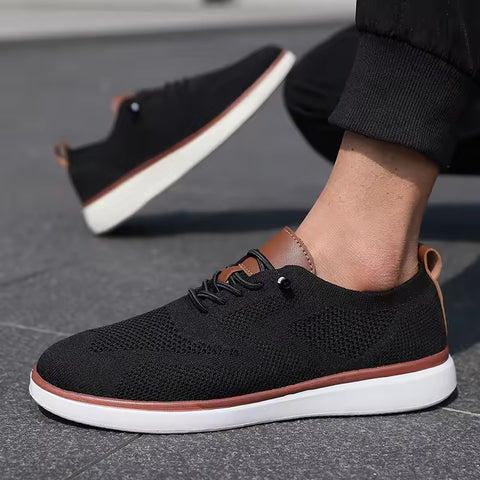 Strider black men's sneakers with discreet height boost, featuring breathable knit upper, brown leather accents, and white sole designed for comfortable all-day wear.