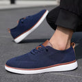 Strider men's sneakers in navy blue with brown accents and white soles, featuring a modern design and discreet height boost for comfortable elevation.