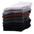 Stack of folded socks in various colors on a white background