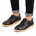 Ardent black casual elevated shoes with white stitching orange accent soles and discreet height increasing design worn with cuffed black jeans