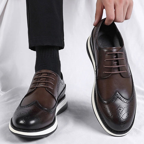 Brown dress shoes with white soles worn by a person on a white background