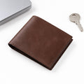 The Modern Wallet in brown leather with a slim bifold design shown beside a laptop and keys for a refined everyday carry accessory