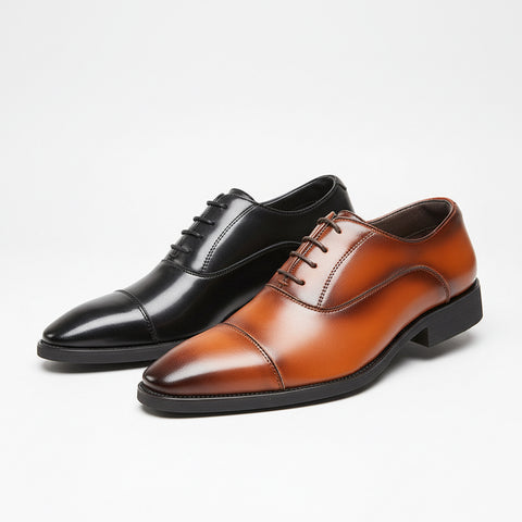 Black and brown leather dress shoes on a wooden surface with a white background