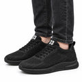 Elevate33 black men's sneakers with a discreet height boost and comfortable cushioned soles shown with dark jeans