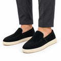Ellison black men's casual slip-on shoes with stitched uppers and cream rubber soles, styled with dark trousers for a polished everyday look and discreet height boost
