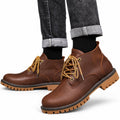 Explorer brown leather casual boots with gold laces and rugged lug soles styled with cuffed jeans for a discreet height boost