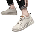Beige sneakers worn with black pants on a white background