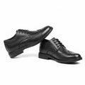 Pair of black dress shoes on white background. 
