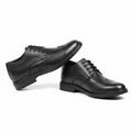 Pair of black Harrington men's dress shoes with classic brogue detailing, featuring a hidden internal lift for a discreet height boost.