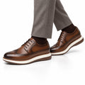 Hartford light brown leather men's dress shoes with brogue detailing and a discreet height boost styled with tailored trousers