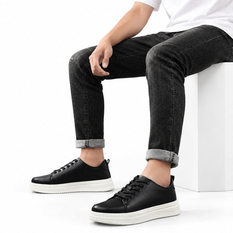 Hawthorn black men's casual shoes with lace up styling and thick white soles shown with rolled black jeans in a clean studio setting