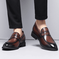 Kensington men's dress shoes in polished brown with black accents, featuring a discreet height boost and hidden internal lift for everyday comfort and elegant style.
