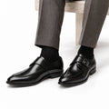 Lennox black leather mens dress shoes with a sleek polished finish and discreet height boost styled with tailored gray trousers
