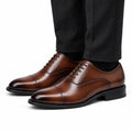 Monarch light brown leather men's dress shoes with cap toes and polished finish styled with black trousers for a discreet height boost