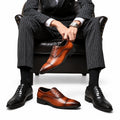 Regal dress shoes in brown and black leather shown with a pinstripe suit, seated in a leather chair