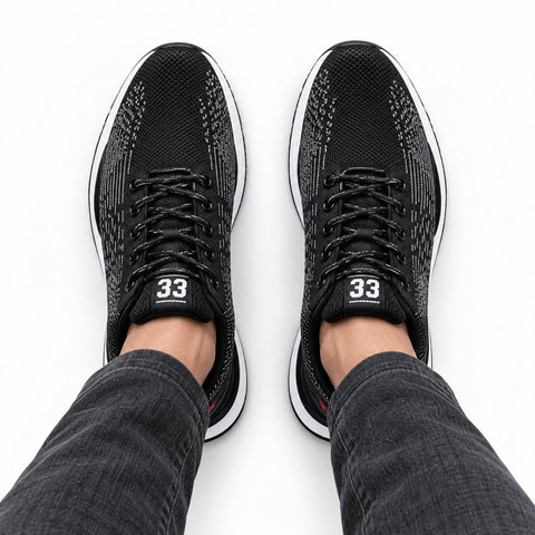 Retro33 black height increasing sneakers with textured knit uppers and lace up design shown worn with dark jeans for a discreet lift and modern style
