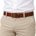 The Classic Belt in brown leather with a brass buckle shown worn with a white shirt and beige trousers