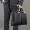 A person holding The Modern Briefcase in black, showing the sturdy handles and structured shape.
