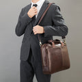 Man in a dark pinstripe suit holding The Modern Briefcase in rich brown.