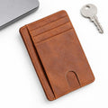 The Modern Cardholder in brown leather with multiple card slots and a slim profile displayed beside a laptop and keys for minimalist everyday carry