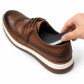 The Modern Insole being placed inside a brown leather wingtip shoe for a discreet height boost and comfortable lift
