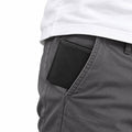 The Modern Wallet black slim wallet tucked into the front pocket of gray trousers for discreet everyday carrying and modern style