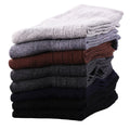 Stack of neatly folded dress socks in neutral colors.